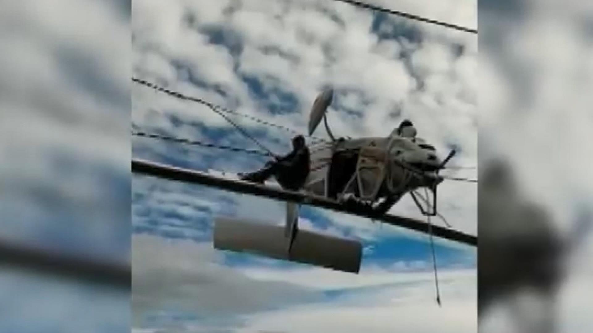 Elektrik tellerinde asılı kalan uçağın pilotu kurtarılmayı bekledi