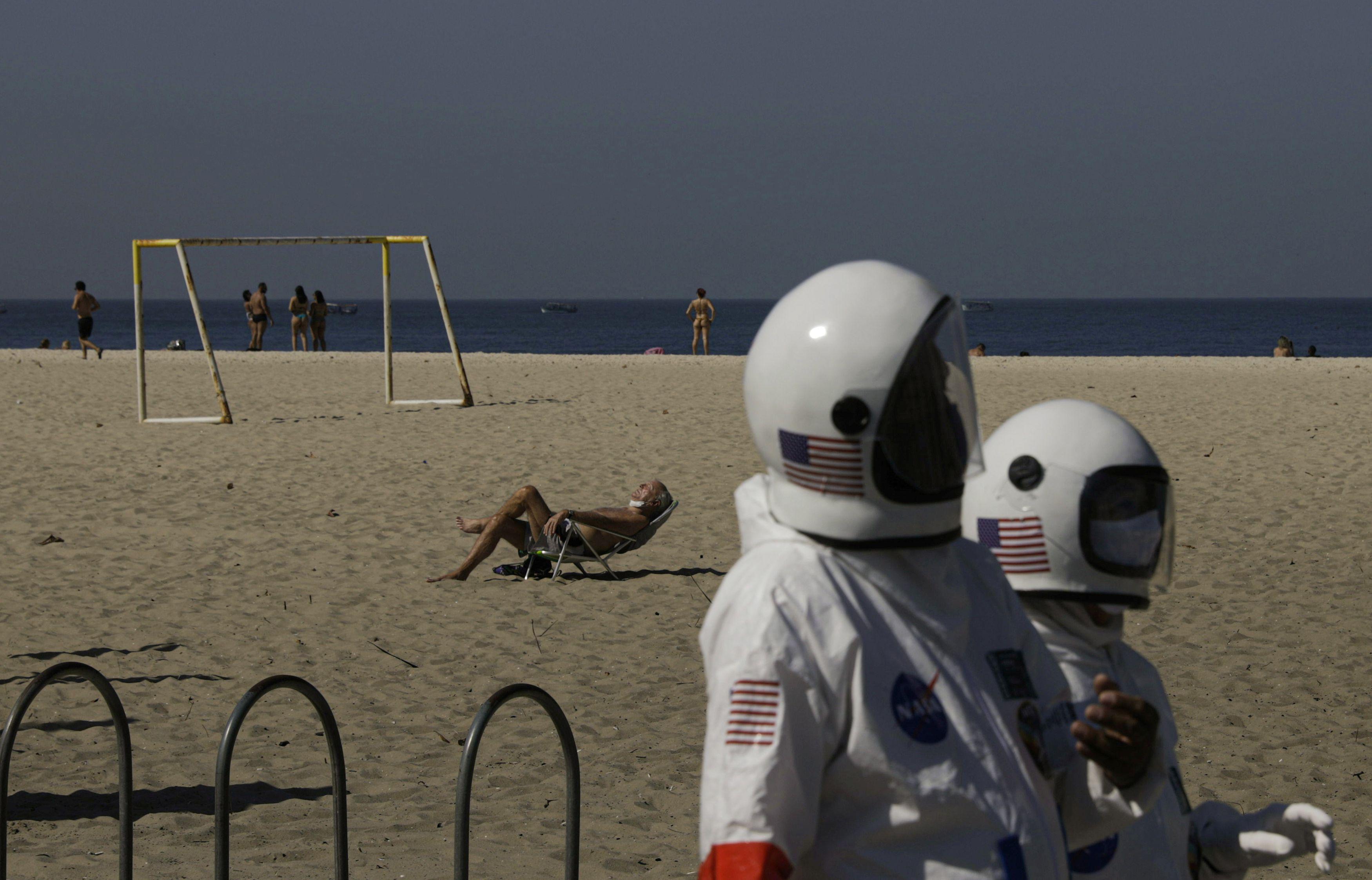 Coronadan korunmak isteyen çift astronot kıyafetiyle plaja indi