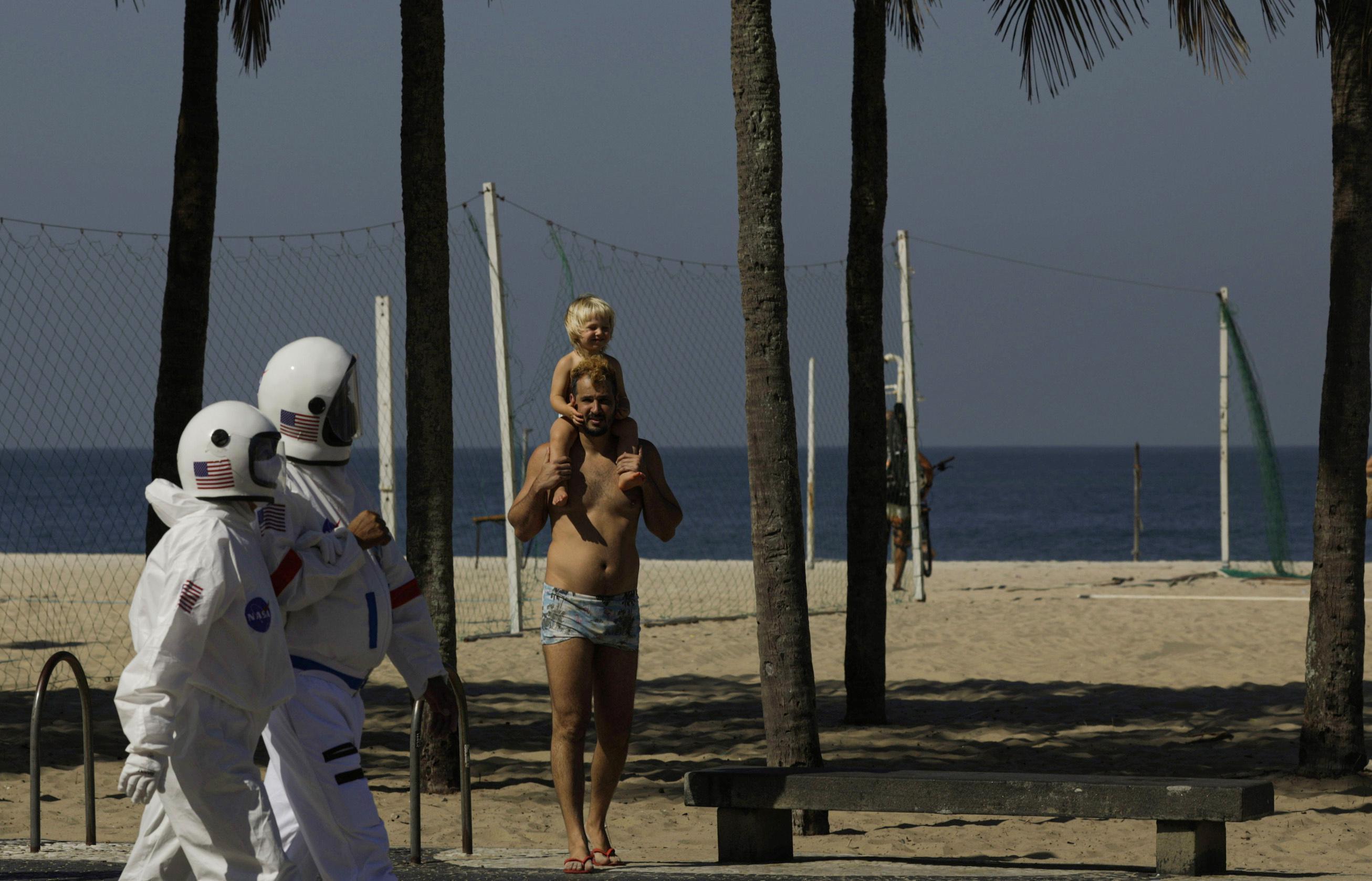 Coronadan korunmak isteyen çift astronot kıyafetiyle plaja indi